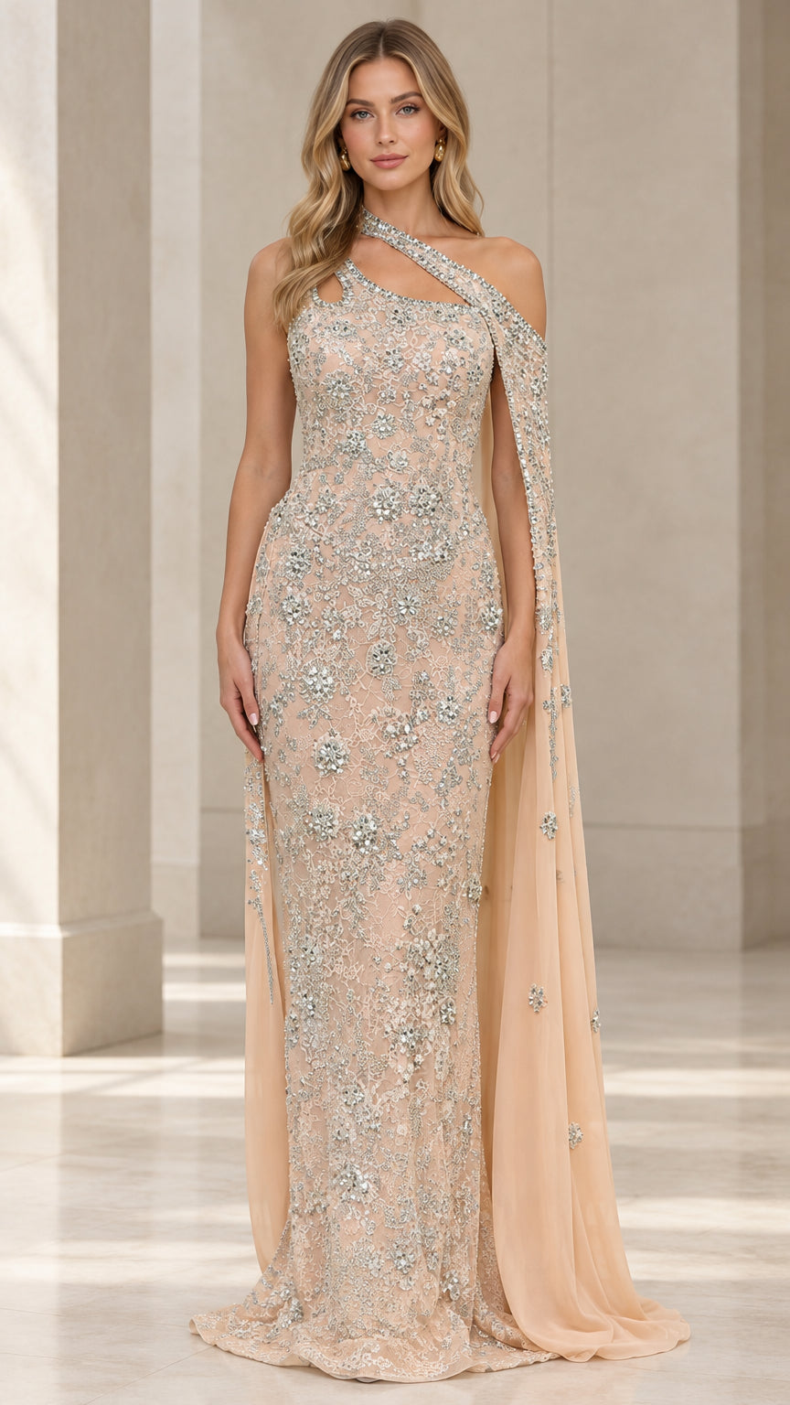 Front view of model wearing champagne embellished one-shoulder lace evening gown with attached cape