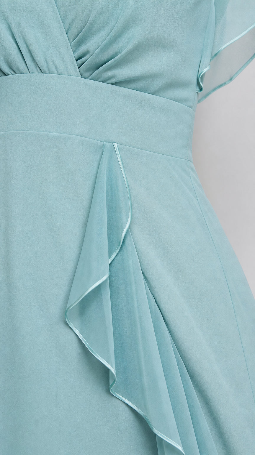 Close-up detail of waistline and cascading chiffon side ruffle on dusty blue dress