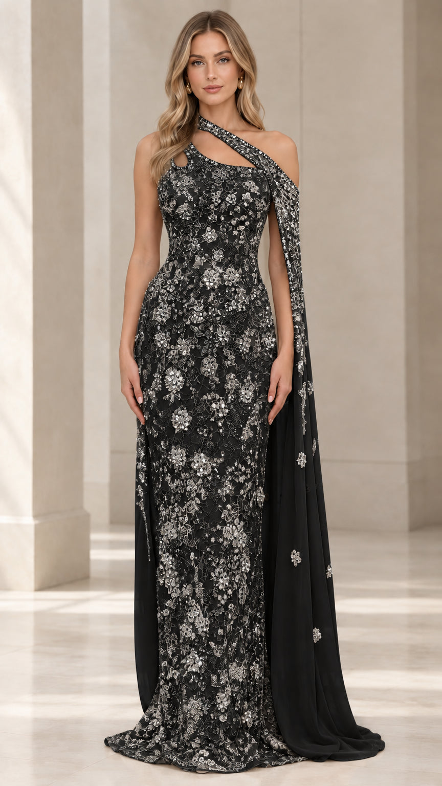 Front view of black crystal-embellished one-shoulder lace evening gown with cape drape