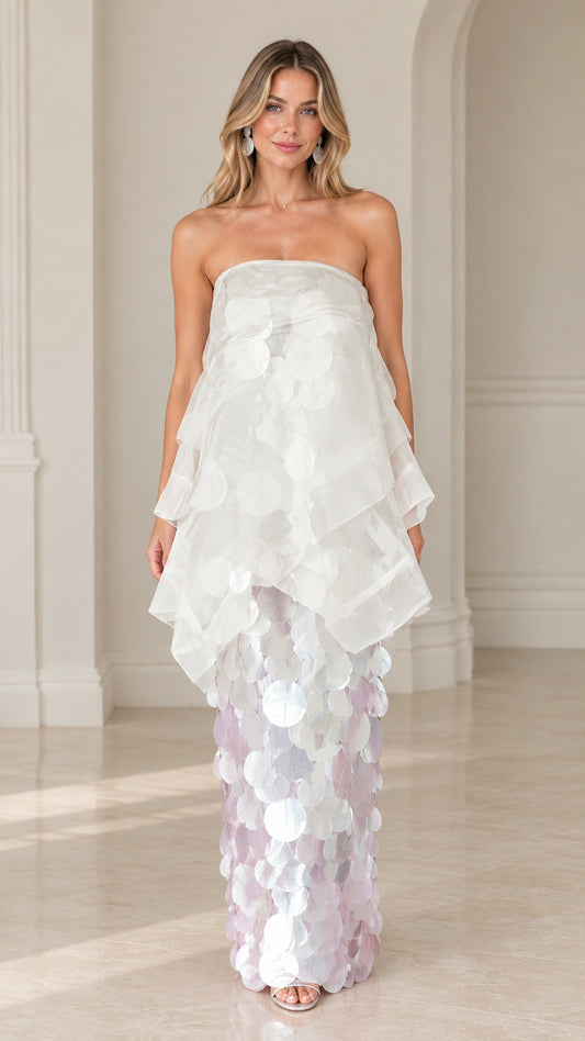 Front view of model wearing a white strapless tiered organza paillette maxi gown