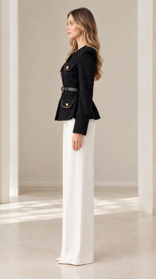 Side profile view of woman wearing black structured tweed jacket with peplum hem
