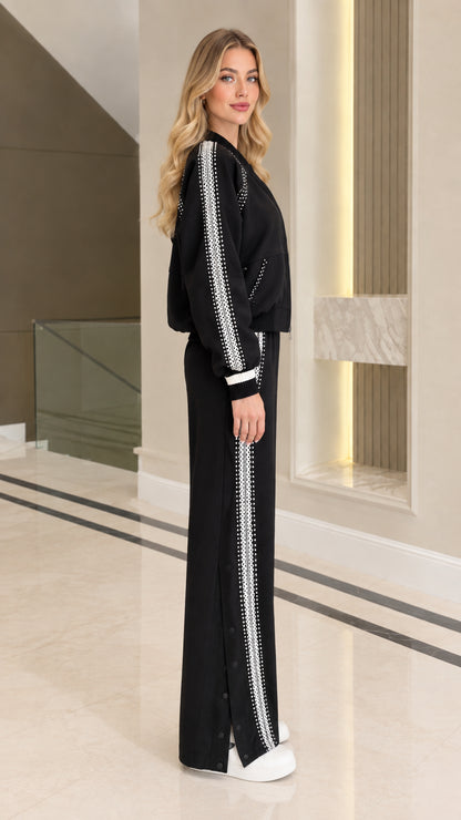 Side view of black tracksuit set showing embellished stripe on jacket sleeves and pants