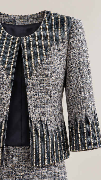 Close-up detail of woven tweed fabric, lining, and intricate beaded trim